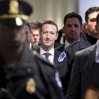 Le fondateur et directeur de Facebook Mark Zuckerberg entouré d'agents de police avant de son audition au Congrès américain. [EPA/Keystone - Michael Reynolds]