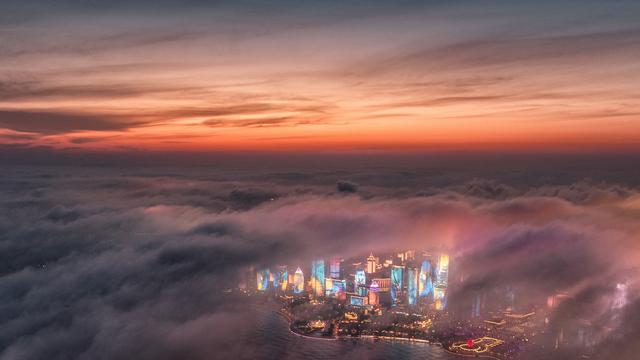 Brouillard artificiel au-dessus des gratte-ciels de Qingdao, à l'est de la Chine. [Keystone - Lu Hui/Xinhua via AP]