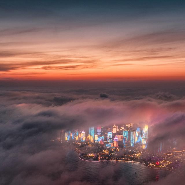 Brouillard artificiel au-dessus des gratte-ciels de Qingdao, à l'est de la Chine. [Keystone - Lu Hui/Xinhua via AP]