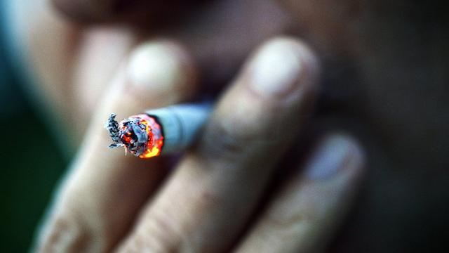 Une personne tire sur sa cigarette. [Keystone - Christophe Schmidt]