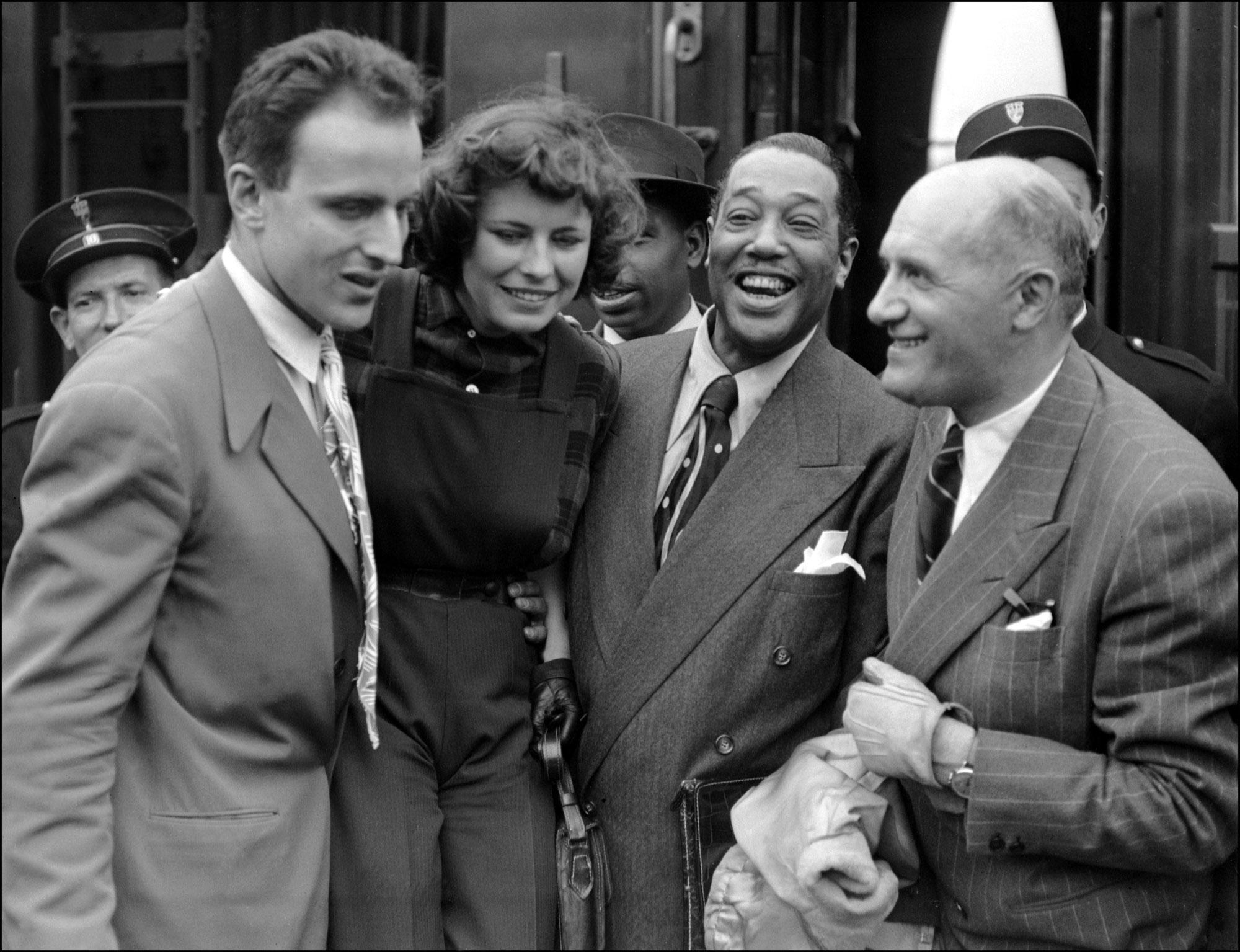 Duke Ellington (C), pianiste, compositeur et chef d'orchestre de jazz américain, accompagné de son manager, Jules Borkon (D), est accueilli par Boris Vian (G) à son arrivée en gare du Nord à Paris le 19 juillet 1948. [AFP]