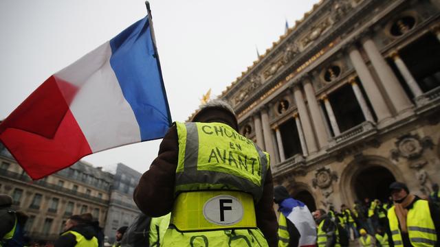 Des manifestants du mouvement des gilets jaunes devant l'Opéra de Paris le samedi 15 décembre 2018. [Keystone - EPA/IAN LANGSDON]