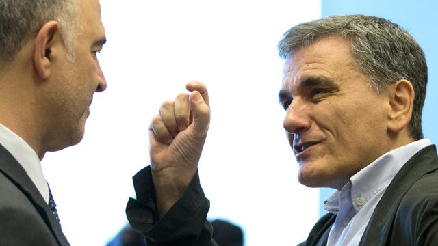 Les créanciers d'Athènes ont trouvé un accord sur la dette grecque, ce qui réjouit le ministre grec des finances Euclide Tsakalotos (à droite) ici face au commissaire européen pour les affaires économiques et financières Pierre Moscovici. [Virginia Mayo]