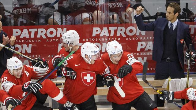 Patrick Fischer exulte à droite de l'image, alors que ces joueurs se précipitent sur la glace fêter la victoire. [Salvatore Di Nolfi]