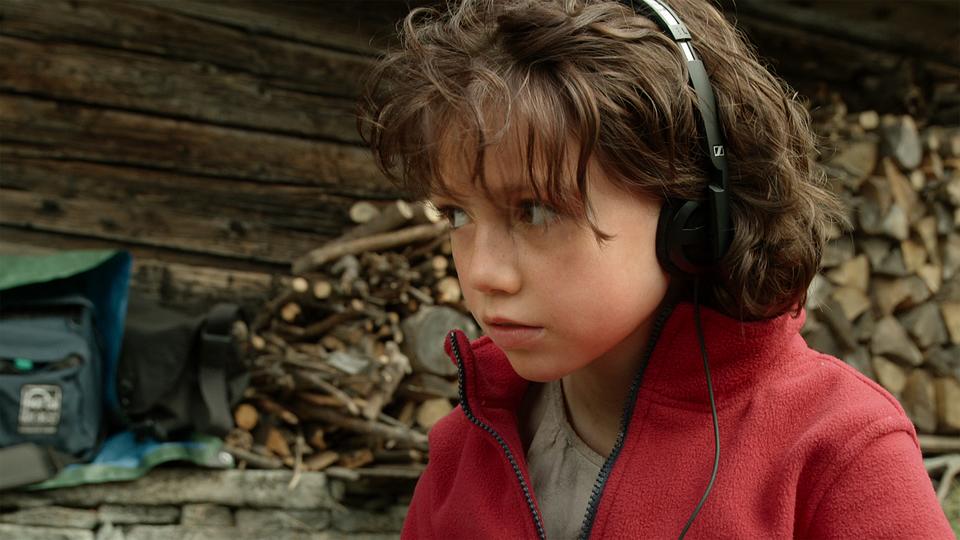 Anuk Steffen joue le rôle-titre du film "Heidi". Curieuse de tout, elle observe l’équipe de tournage et, plus particulièrement, le travail de l’ingénieur du son. [La Lanterne Magique - © Milos-Films SA]