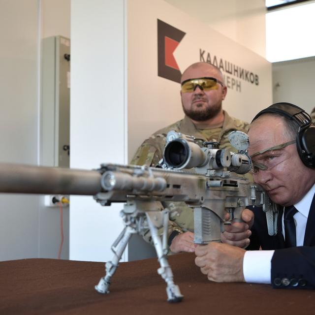 Le président russe Vladimir Poutine teste un fusil de tireur d'élite dans un parc d'attractions dédié à l'équipement militaire des troupes russes. [EPA/Sputnik/Kremlin Pool/Keystone]
