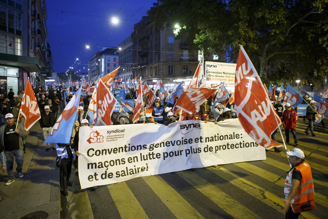 Plus d'un millier d'ouvriers du bâtiment défilent dans les rues de Genève, lors de la journée de grève des maçons. [Keystone - Salvatore Di Nolfi]