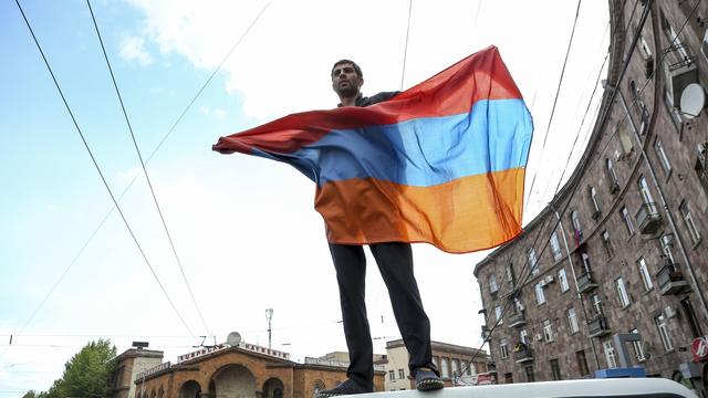 Un manifestants brandit le drapeau arménien durant un rassemblement de protestation, le 22 avril 2018. [Keystone - Aram Kirakosyan]
