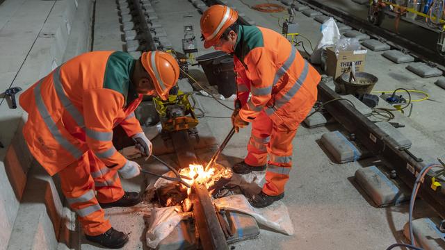 La cérémonie de soudage des rails s'est déroulée sous la rivière du Foron, qui délimite la frontière la frontière entre la France et la Suisse. [Keystone - Martial Trezzini]