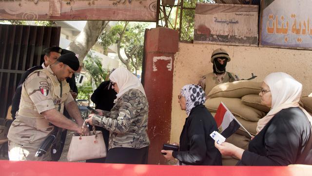 Des contrôles de sécurité à l'entrée des bureaux de vote au Caire. [Keystone - AP Photo/Amr Nabil]