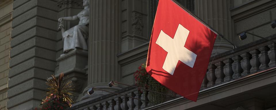 Un drapeau suisse accroché au Palais fédéral. [Keystone - Alessandro della Valle]