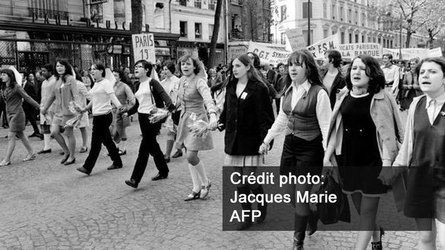 Des jeunes filles défilent pour la fête du Travail, le 1er mai 1968. [AFP - Jacques Marie]