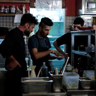 Un cuisinier prépare une spécialité syrienne dans le cadre du Refugee Food Festival à Athènes, en juin 2017. [Reuters - Costas Baltas]