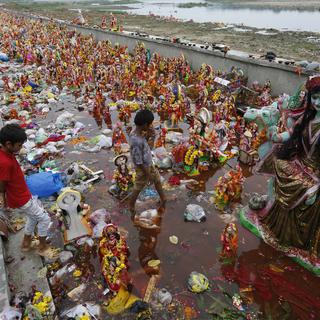 Mardi 21 août: des enfants cherchent des objets réutilisables parmi des offrandes à la déesse hindoue Dashama déposées près de la rivière Sabarmati à Ahmedabad, dans l'ouest de l'Inde. [Keystone - AP Photo/Ajit Solanki]