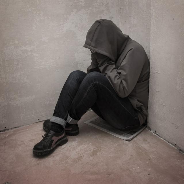 Un adolescent sans abris est assis au pied d'un mur. [Fotolia - dashtik]