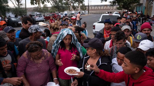 Des migrants - pour la plupart arrivés du Honduras - reçoivent de la nourriture à Tijuana, ville mexicaine à la frontière avec les Etats-Unis. [AFP - Guillermo Arias]