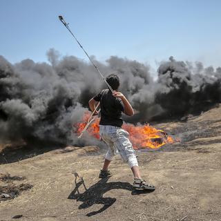 Un manifestant palestinien à la frontière israélienne à l'est de la Bande de Gaza. [EPA/Keystone - Mohammed Saber]