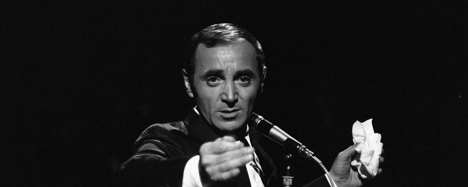 Charles Aznavour derrière le micro lors de l'enregistrement d'un numéro de "Palmarès des chansons". [AFP - Bernard Pascucci / Ina]