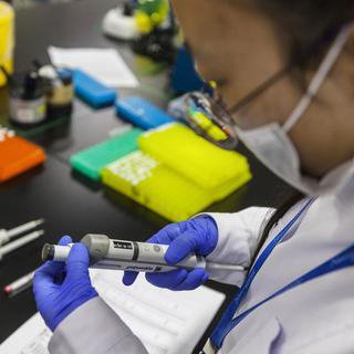 Une scientifique chinoise travaille dans un laboratoire de recherche sur l'ADN. [Keystone - Aleksandar Plavevski]