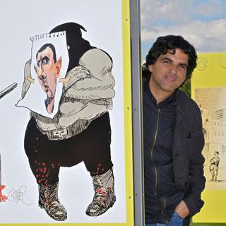 Le dessinateur Patrick Chappatte pose avec ses dessins en 2012 à Genève. [Keystone - Martial Trezzini]