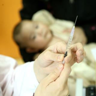 Un médecin s'apprête à administrer un vaccin à un bébé dans un hôpital de Shanghai, en Chine. [Imagechina/AFP - Wang Yadong]