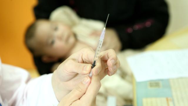 Un médecin s'apprête à administrer un vaccin à un bébé dans un hôpital de Shanghai, en Chine. [Imagechina/AFP - Wang Yadong]