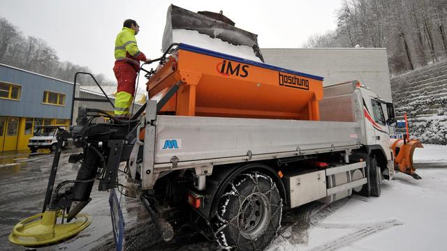 Un employé de la ville de Lausanne remplissant un véhicule de la voirie de sel de déneigement (image d'illustration). [KEystone - Dominic Favre]