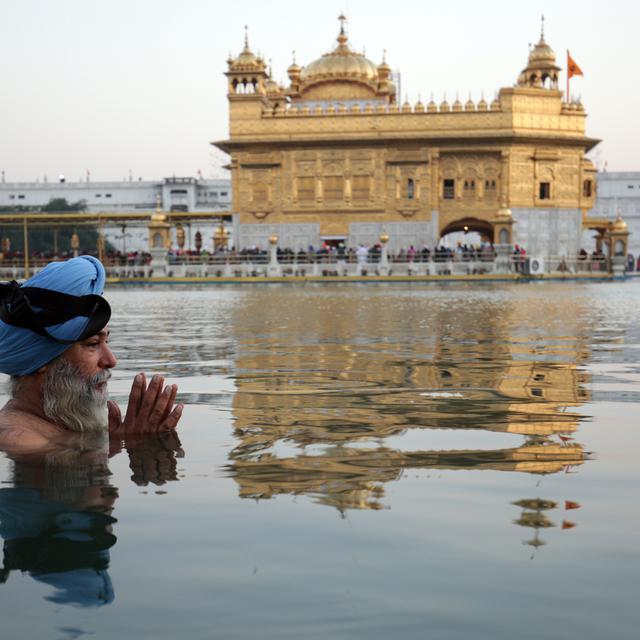 Vendredi 23 novembre: un sikh priant devant le temple d'or, édifice le plus sacré de sa religion à Amritsar, en Inde. [Keystone - EPA/Raminder Pal Singh]