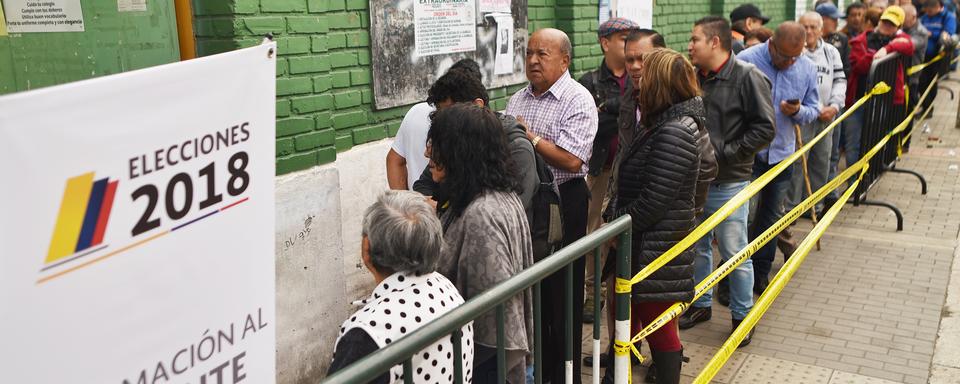 Des électeurs font la queue devant un bureau de vote à Bogota en Colombie, pour le deuxième tour de l'élection présidentielle, le 17 juin 2018. [AFP - Luis Robayo]