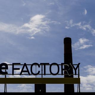 Le logo de Blue Factory derrière la cheminée de l'ancienne brasserie Cardinal à Fribourg. [Keystone - Jean-Christophe Bott]
