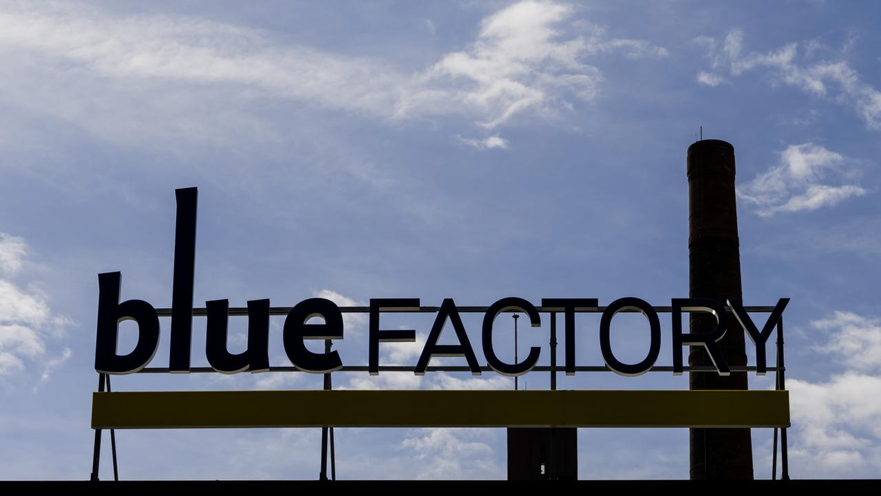 Le logo de Blue Factory derrière la cheminée de l'ancienne brasserie Cardinal à Fribourg. [Keystone - Jean-Christophe Bott]