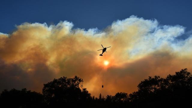 Un hélicoptère lutte contre les feux de forêt en Californie. [AFP - Josh Edelson]