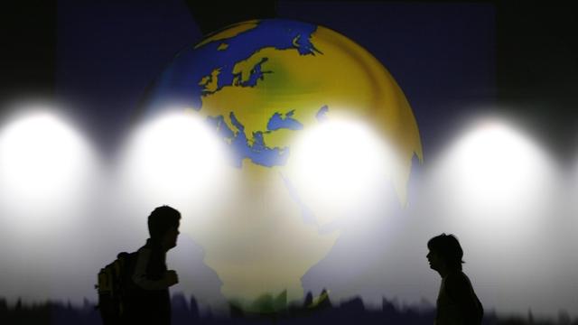 Des volontaires passent devant une carte du monde lors du World Economic Forum de Davos en janvier 2008. [Reuters - Stefan Wermuth]