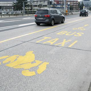 Une route à Genève avec une bande réservée aux bus, motos, vélos, taxis et bus. (Image d'illustration) [Keystone - Salvatore Di Nolfi)]