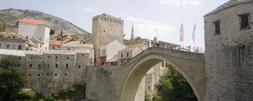 Le pont de Mostar - reconstruit en 2004 - peine à rapprocher Bosniaques et Croates habitant une ville toujours divisée. [Wikimedia - Inkey]