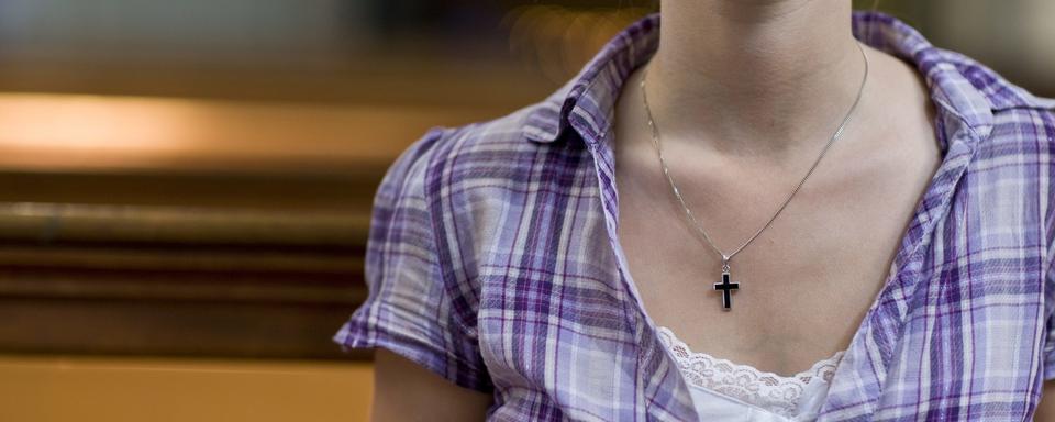 Une femme dans une église catholique de Berne. [Keystone - Alessandro Della Bella]