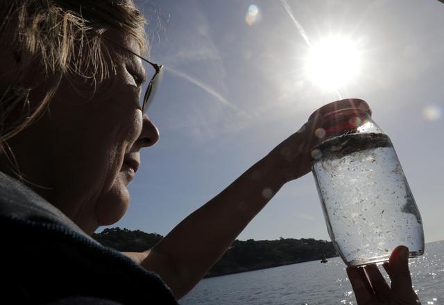 Une chercheuse étudiant les dégâts des microplastiques en train d'analyser un échantillon d'eau prélevé en Méditerranée. [Reuters - Eric Gaillard]