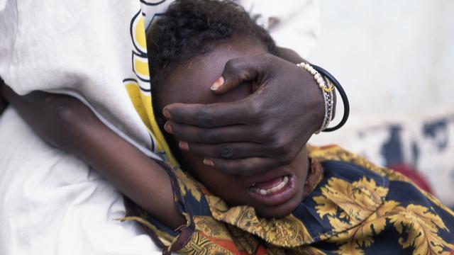 Une fillette de 6 ans, maintenue par sa soeur, crie de douleur alors qu'elle subit une circoncision, à Hargeisa en Somalie. [Keystone - Jean-Marc Bouju]