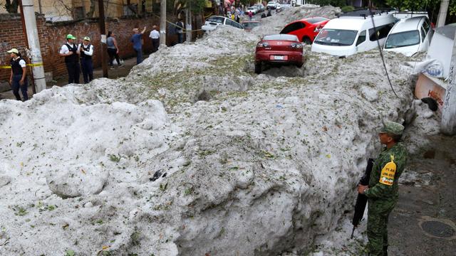 La glace s'est accumulée dans les rues Guadalajara, dans le nord du Mexique, emportant plusieurs voitures le 30 juin 2019. [Keystone - EPA/Francisco Guasco]