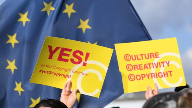 Des partisans de la très attendue réforme sur le copyright devant le Parlement européen, le 26 mars 2019. [Keystone - PATRICK SEEGER]