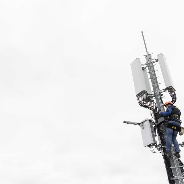 Un employé de l'entreprise Axians installe une antenne 5G à Chêne-Bougeries, en avril 2019. [Keystone - Martial Trezzini]