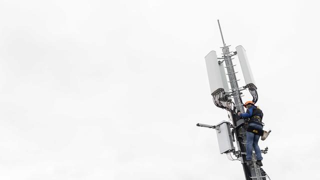 Un employé de l'entreprise Axians installe une antenne 5G à Chêne-Bougeries, en avril 2019. [Keystone - Martial Trezzini]