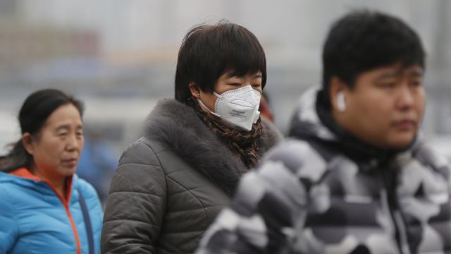 Des citoyens chinois d'humeur apparemment morose, le 26 novembre 2018, lors d'un pic de pollution de l'air à Pékin. [EPA - WU HONG]