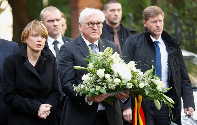 Le président allemand, Frank-Walter Steinmeier, porte une gerbe de fleurs devant la synagogue de Halle, le 10 octobre 2019. [Reuters - Hannibal Hanschke]