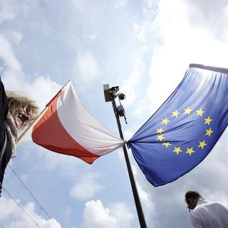Un drapeau de la Pologne et de l'UE attachés durant une manifestation à Varsovie, le 18 mai 2019. [AFP - Jaap Arriens]