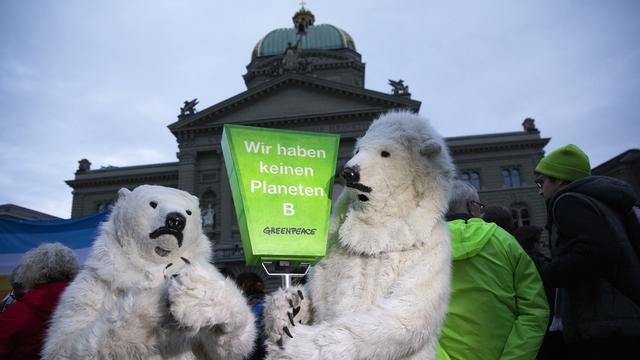 Des militants de l'initiative pour les glaciers sur la place fédérale à Berne. [Keystone - Peter Klaunzer]