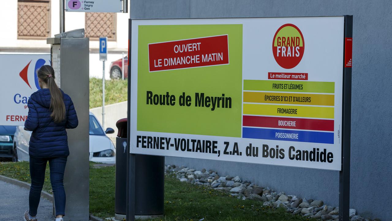 Un panneau publicitaire à Genève vantant l'ouverture le dimanche d'un magasin français. [Keystone - Salvatore Di Nolfi]