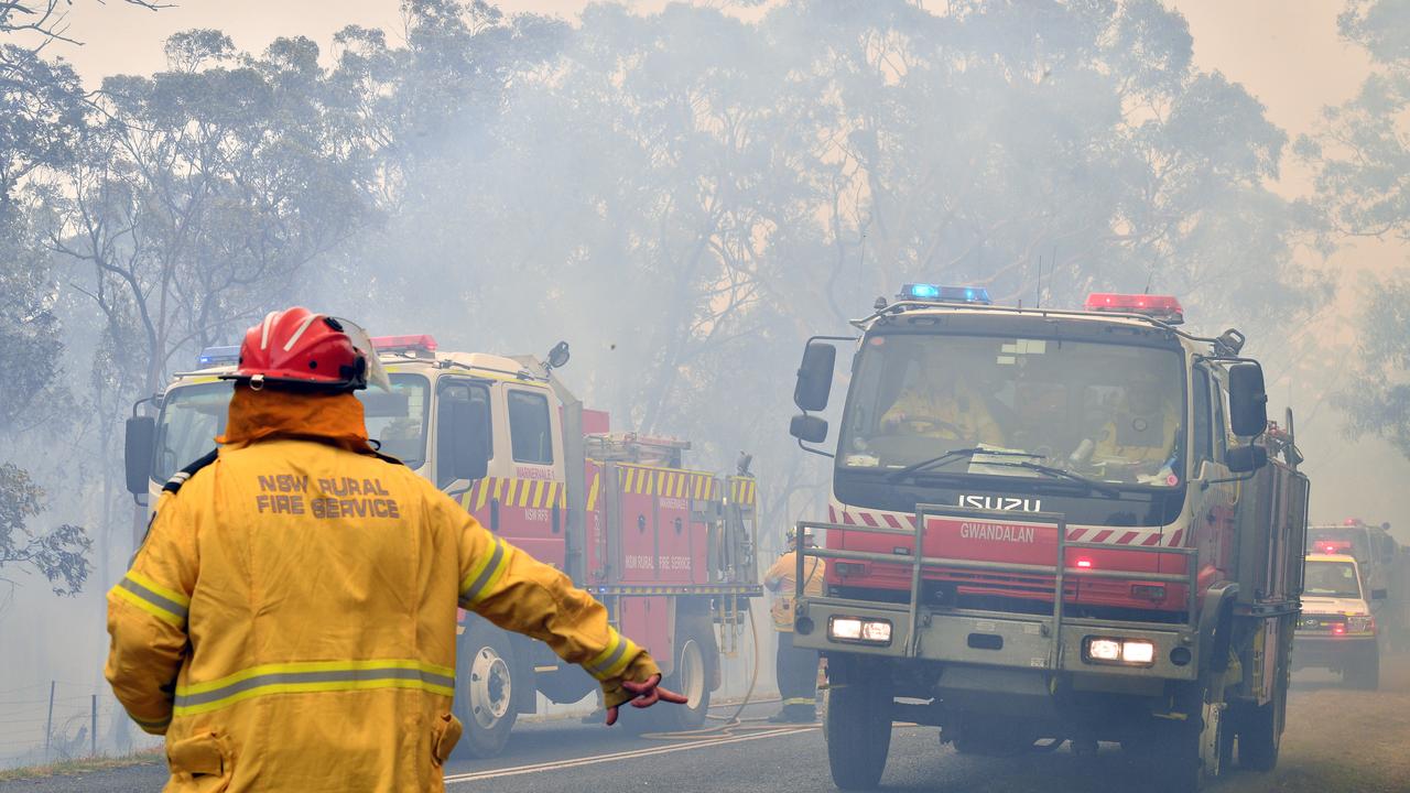 Des pompiers cherchent à sécuriser des zones résidentielles alors que des incendies font rage sur la Côte Centrale, à environ 100 kilomètres de Sydney. [AP Photo - Saeed Kahn]