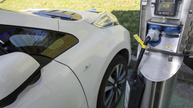 Une voiture électrique parquée près d'une borne de recharge près de Genève. [Keystone - Martial Trezzini]