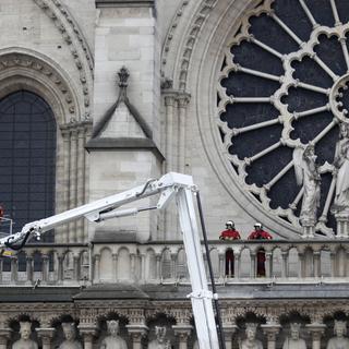 Des pompiers s'activaient encore mardi matin sur la façade de Notre-Dame de Paris. [AP Photo - Thibault Camus]